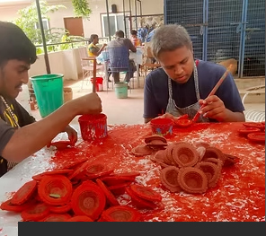 A participant painting a diya